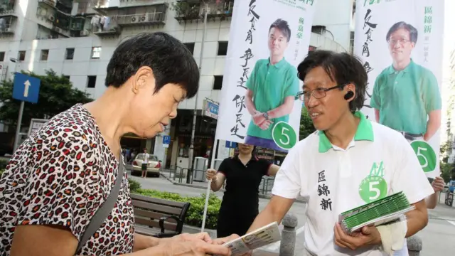 2013年9月6日,民主黨候選人區錦新在澳門派發立法會選舉傳單。